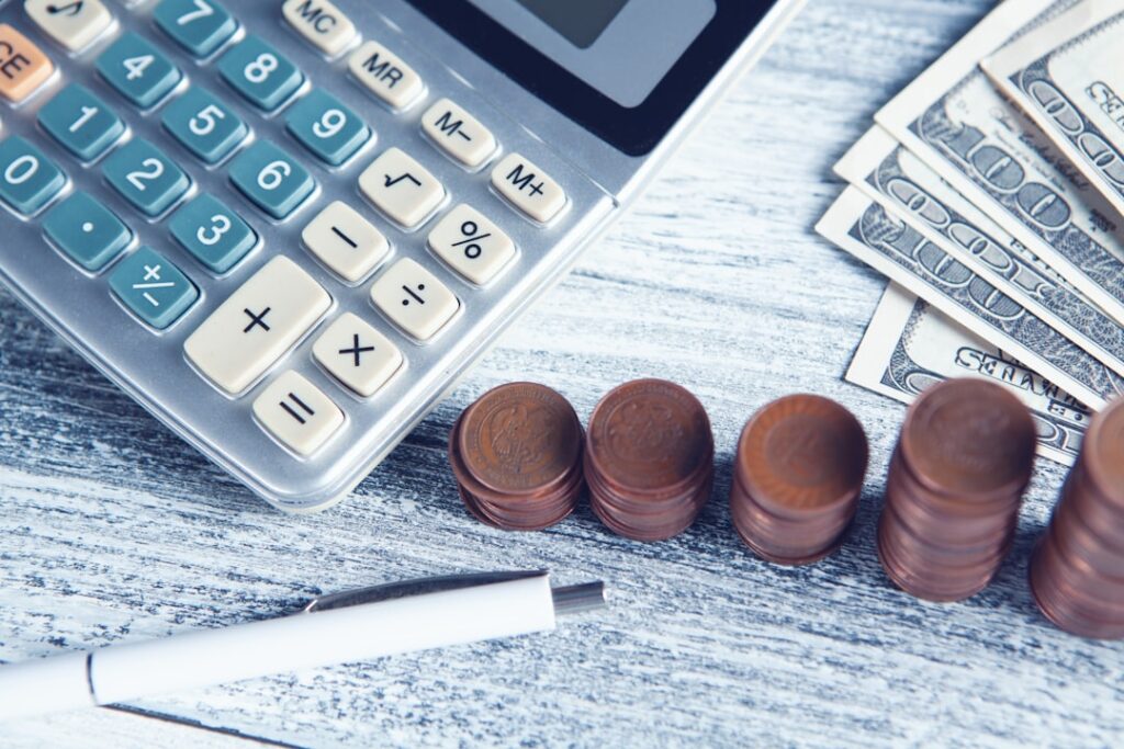 Calculator and coins on a table representing cost comparison