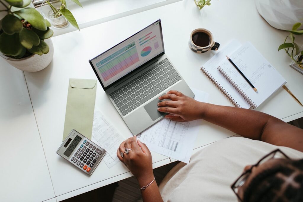Person planning budget with calculator and notebook
