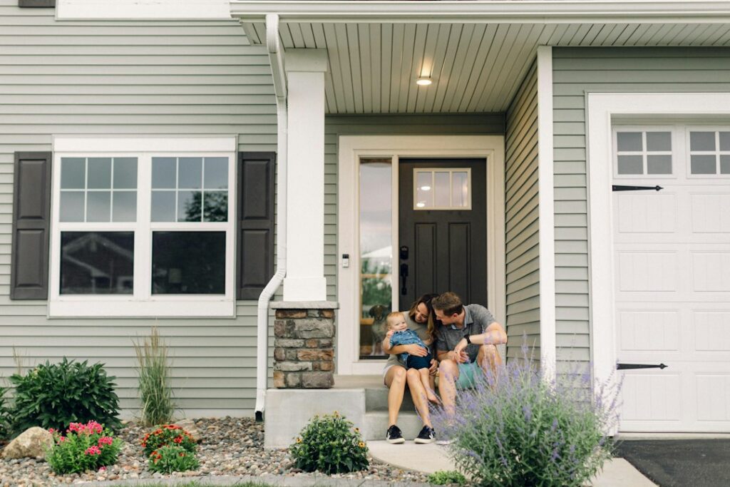 Young family sitting outside their new home